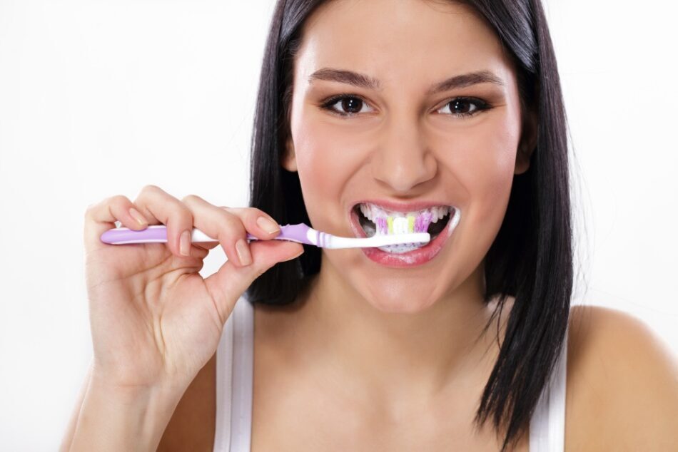 women brushing her teeth for oral care